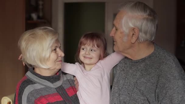 Lächelnder Familiengroßvater, Großmutter mit Enkelin zu Hause - Filmmaterial, Video