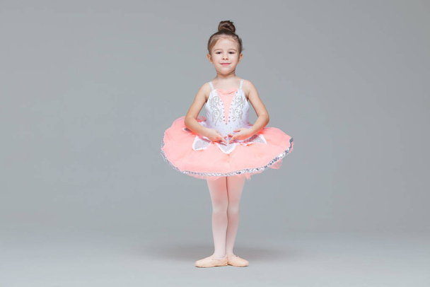 Cute adorable ballerina little girl in pink tutu dance practices ballet dancing - Photo, image