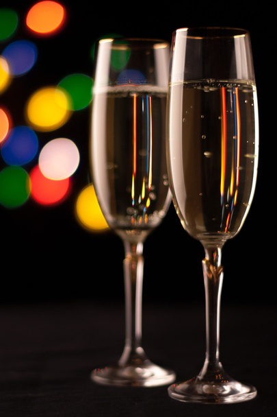 two glasses of champagne toasting against bokeh lights background - Φωτογραφία, εικόνα