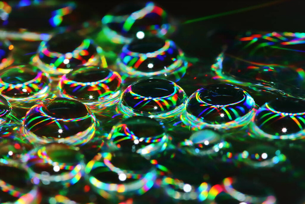 Капля на диске крупным планом на красивом световом фоне
 - Фото, изображение