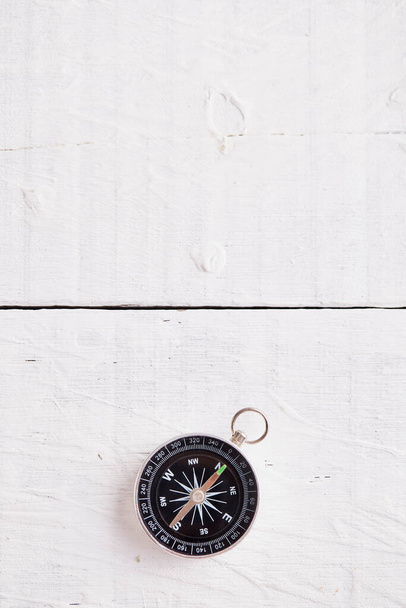 Compass on the white wooden table background, concept for direction, travel, guidance or assistance - Zdjęcie, obraz