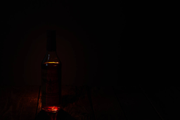 Ukraine, Dnipro - April 06, 2020. horneburger 1939 whiskey of the third reich found in the cellar stands by candles in a dark room of the house - 写真・画像