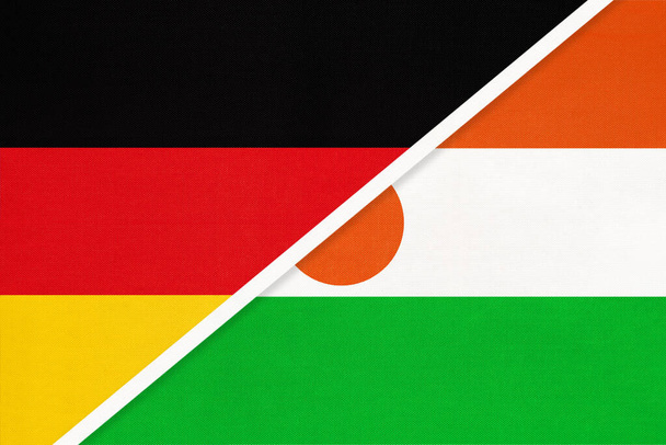 Bundesrepublik Deutschland gegen Niger, Symbol zweier Nationalflaggen aus Textil. Beziehungen, Partnerschaft und Meisterschaft zwischen europäischen und afrikanischen Ländern. - Foto, Bild
