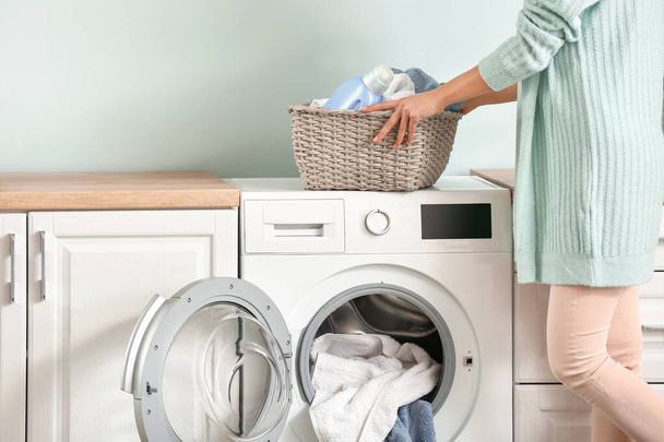 Evde çamaşır yıkayan genç bir kadın. - Fotoğraf, Görsel
