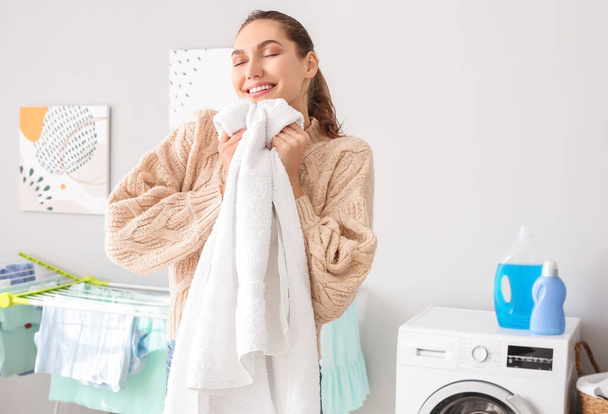 Młoda kobieta z czystym praniem w domu - Zdjęcie, obraz