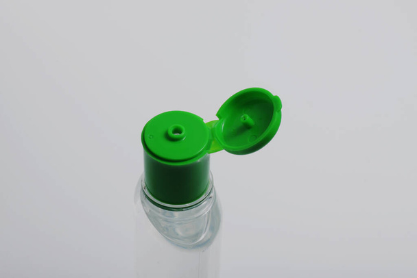 Händedesinfiziertes Gel auf einer klaren Flasche mit grünem Deckel, isoliert - Foto, Bild