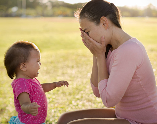 Surullinen onneton äiti ei tiedä, miten huolehtia hänen itkevästä vauvastaan puistossa. Synnytyksen jälkeinen masennus
. - Valokuva, kuva
