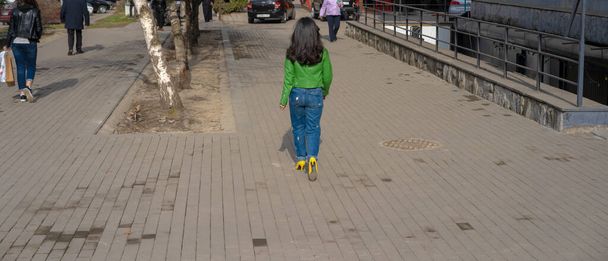 A girl in colorful clothes is walking along the street - Photo, Image