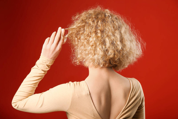 Young woman with beautiful short curly hair on color background - Photo, Image