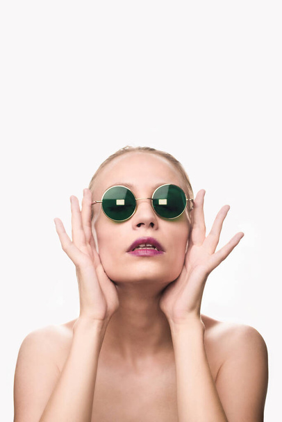Модна модель дівчини в зелених сонцезахисних окулярах ізольована на білому тлі, дивлячись на камеру. Студійний знімок
. - Фото, зображення