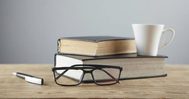 Glasses, pen, book on wooden table. - Fotoğraf, Görsel