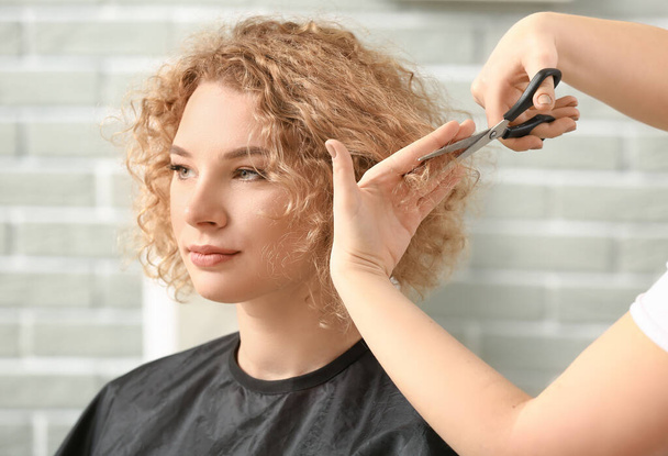 Professional hairdresser working with client in beauty salon - Фото, зображення