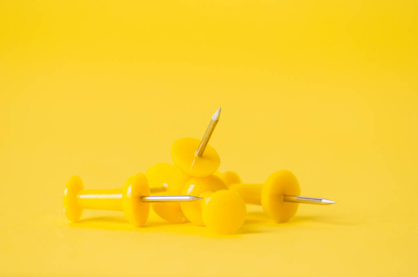 Σπρώξτε καρφίτσες σε κίτρινο φόντο. Δημιουργία ομάδας, επιχείρηση και πωλήσεις έννοια - Φωτογραφία, εικόνα