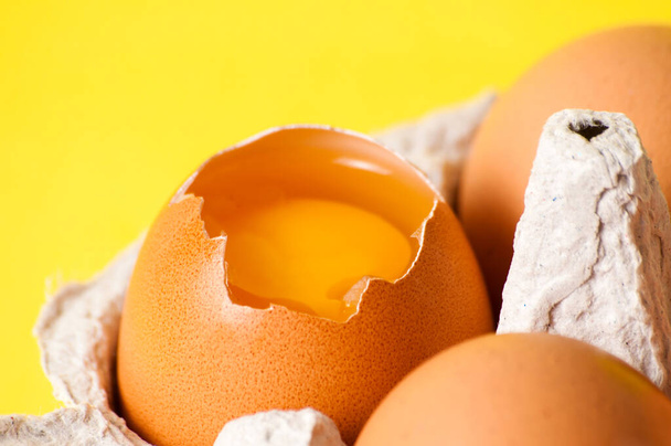 Внутренний макрос яичного желтка крупным планом. Куриные яйца в лотке на желтом фоне
 - Фото, изображение
