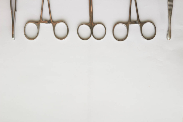 Lékařské nástroje, curettage, křeče, kleště a nůžky na bílém pozadí s kopírovacím prostorem - Fotografie, Obrázek