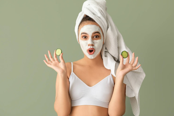Beautiful young African-American woman with cucumber slices and facial mask on color background - Fotografie, Obrázek