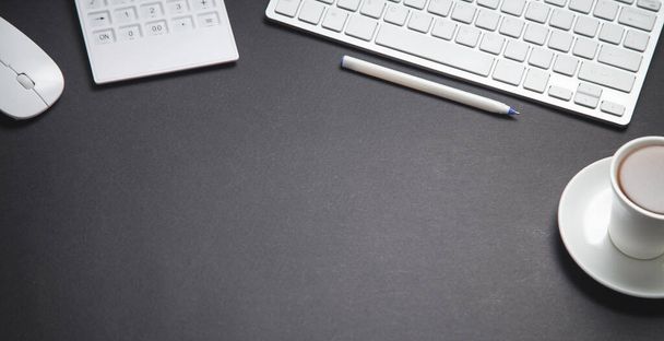 Кофе, компьютерная клавиатура, мышь, ручка, калькулятор. Современный черный рабочий стол. Офис
 - Фото, изображение