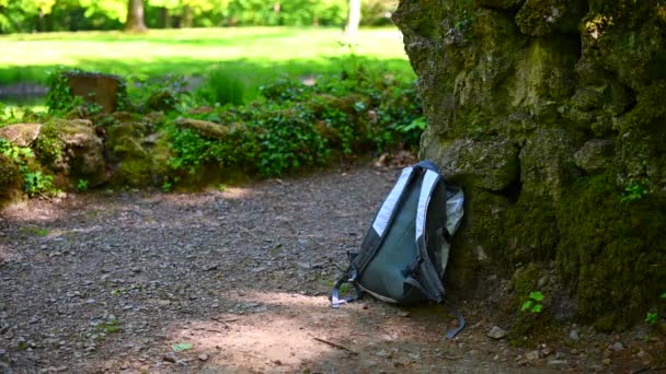 een zak ligt tegen een oude stenen muur en wordt zorgvuldig en zorgvuldig gestolen door een man - Video