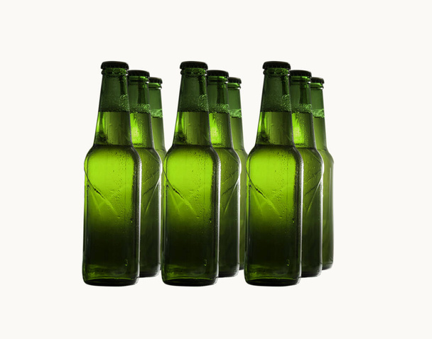 Garrafas de cerveja verde em fileiras isoladas em um fundo branco
. - Foto, Imagem