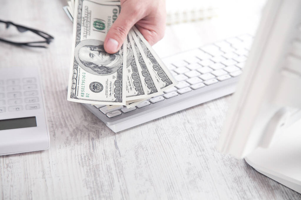  Mão masculina mostrando notas de cem dólares no fundo da mesa de negócios
. - Foto, Imagem