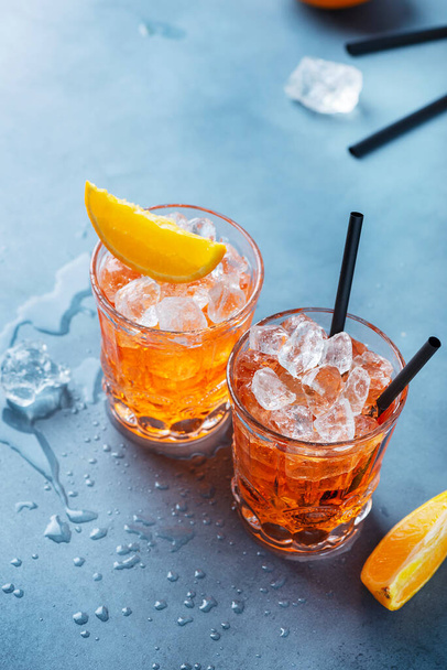 Two glasses of a traitional Italian cocktail aperrol spritz with orange and ice. Selective focus imge with a copy space for your text. - Фото, зображення