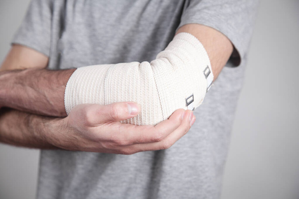Man hand with elastic bandage on elbow. - Photo, Image