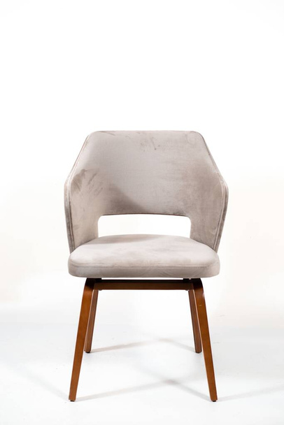 A vertical shot of a white chair with wooden legs behind a white background - Fotoğraf, Görsel