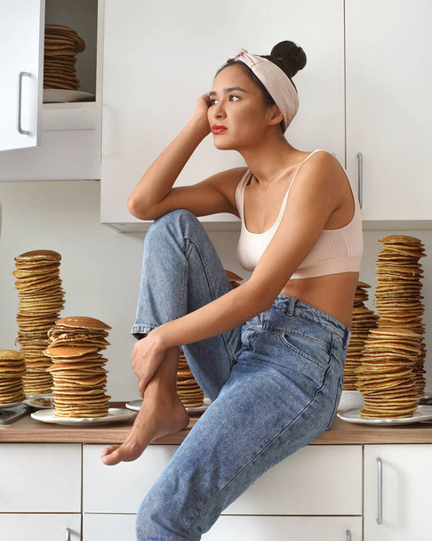 The bored woman sitting in the kitchen surrounded by pancakes #LockdownArt - Foto, afbeelding