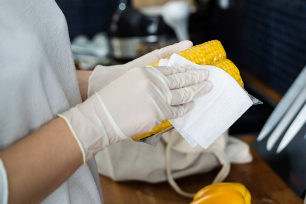 Mujer desinfectando comestibles y otros alimentos en casa
 - Foto, imagen