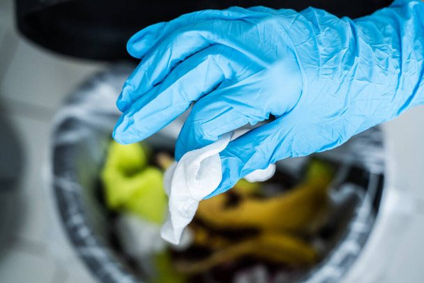 Hand In Glove Throwing Away Dirty Sanitizing Wipe - Photo, image