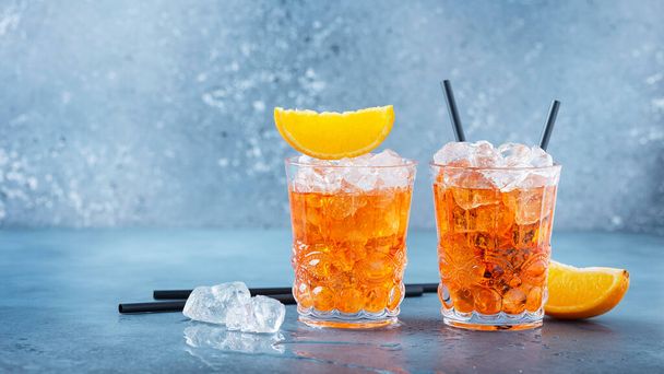 Two glasses of a traitional Italian cocktail aperrol spritz with orange and ice. Selective focus imge with a copy space for your text. Slider format - Фото, зображення
