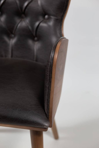 A black leather armchair placed on a white background - Φωτογραφία, εικόνα