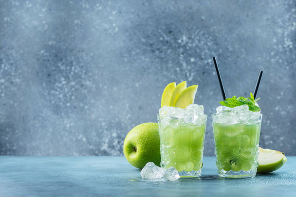 Green cocktail with ice and mint. Bar concept. Apple mojito with mint and ice on the blue background, selective focus image - Foto, Imagen