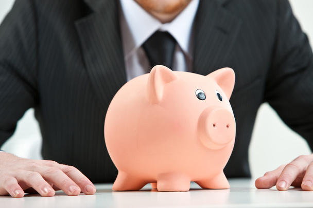 piggybank on foreground on a businesman background - Foto, immagini