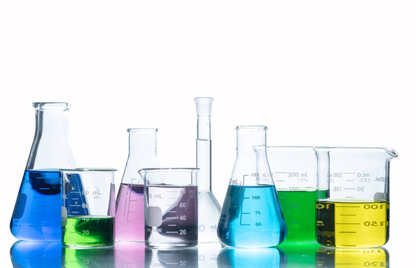 異なる色の液体を持つ実験室用ガラス製品,白の背景とクリッピングパス上に隔離された実験室での科学実験のためのフラスコと測定ビーカー,科学機器 - 写真・画像