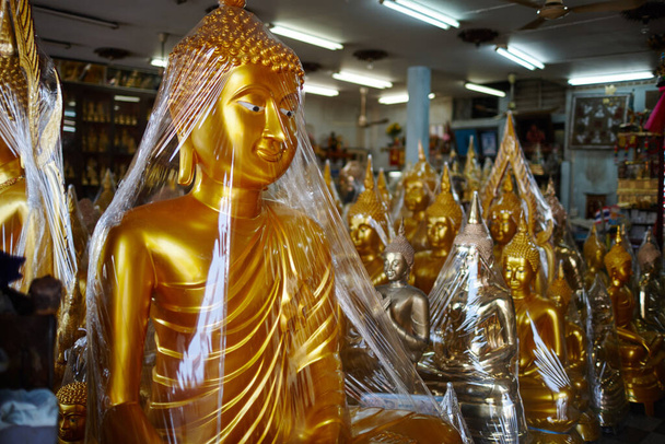 διάφορα θρησκευτικά χρυσά ειδώλια σε κατάστημα με σουβενίρ - Φωτογραφία, εικόνα