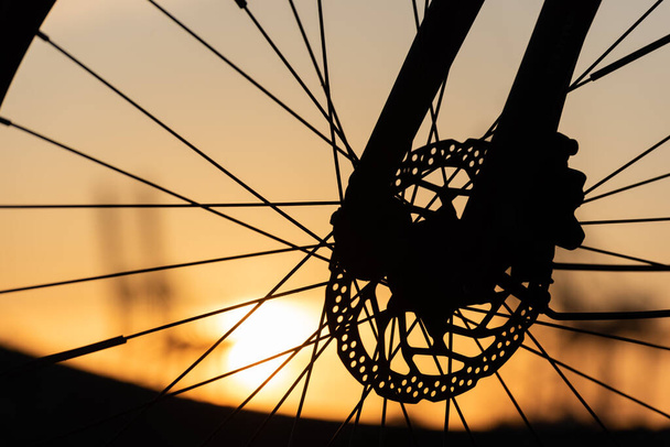 Perfil de una rueda de bicicleta con frenos de disco al atardecer
.. - Foto, Imagen