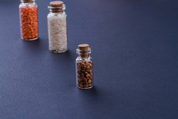 Récipients en verre avec bouchons en liège remplis de grains
. - Photo, image