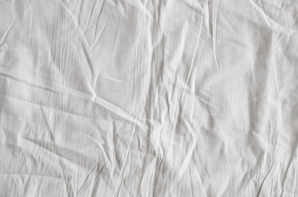Ansicht von Falten auf einem ungemachten Bettlaken nach dem Aufwachen am Morgen. - Foto, Bild