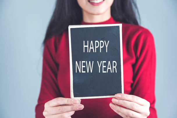 kobieta ręka szczęśliwy nowy rok tekst na tablicy  - Zdjęcie, obraz