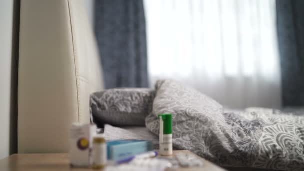 Sypialnia z tabletkami w blistrach i innymi lekami na stoliku nocnym - Materiał filmowy, wideo