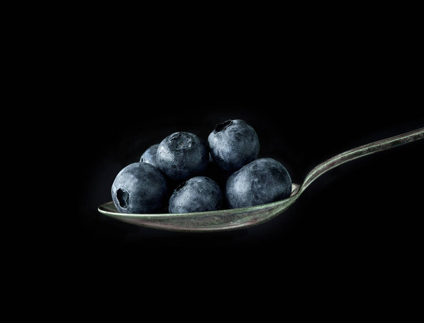 spoon of blueberries on black background - Photo, Image