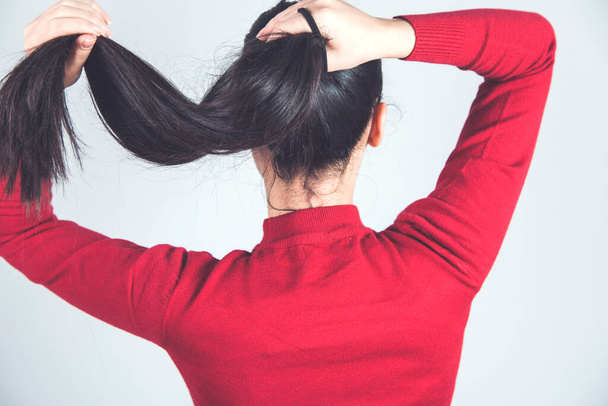 woman hand hair tail on gray background - Valokuva, kuva