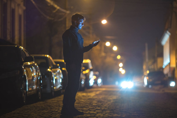 Sokaktaki erkek telefonu. İyi akşamlar gece. Telefoto mercek görüntüsü - Fotoğraf, Görsel