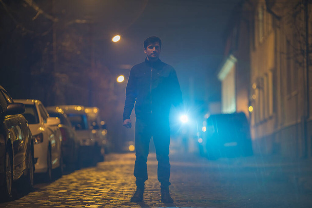 L'homme avec une lampe de poche se tient dans la rue. Soirée nuit
 - Photo, image