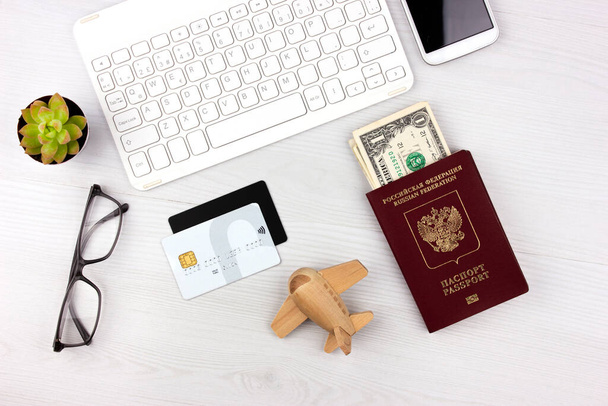 Online booking hotel and plane tickets. Life after coronavirus. Travel tour buying. Flatlay with passport, plane and money - Valokuva, kuva