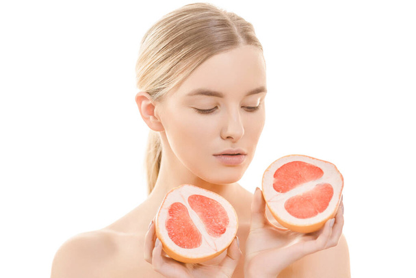 Die süße Frau hält eine Grapefruit auf dem weißen Hintergrund - Foto, Bild