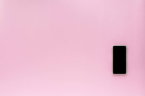 Smartphone auf rosa Hintergrund mit Kopierraum für Kommunikations- und Medientechnik-Konzept - Foto, Bild