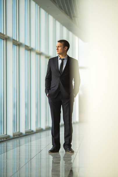 The businessman stand near the panoramic window - Zdjęcie, obraz
