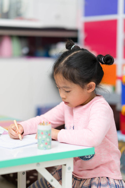 cute asian thai girl child kid sit and draw coloring homework on table happy cheerful - Foto, immagini
